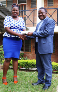 Rev. Fr. Henry Saindi, ECM Sec. General Presents a cheque to Ms. Yvone Sundu, Chairperson MISA Malawi at ECM Secretariat in Lilongwe